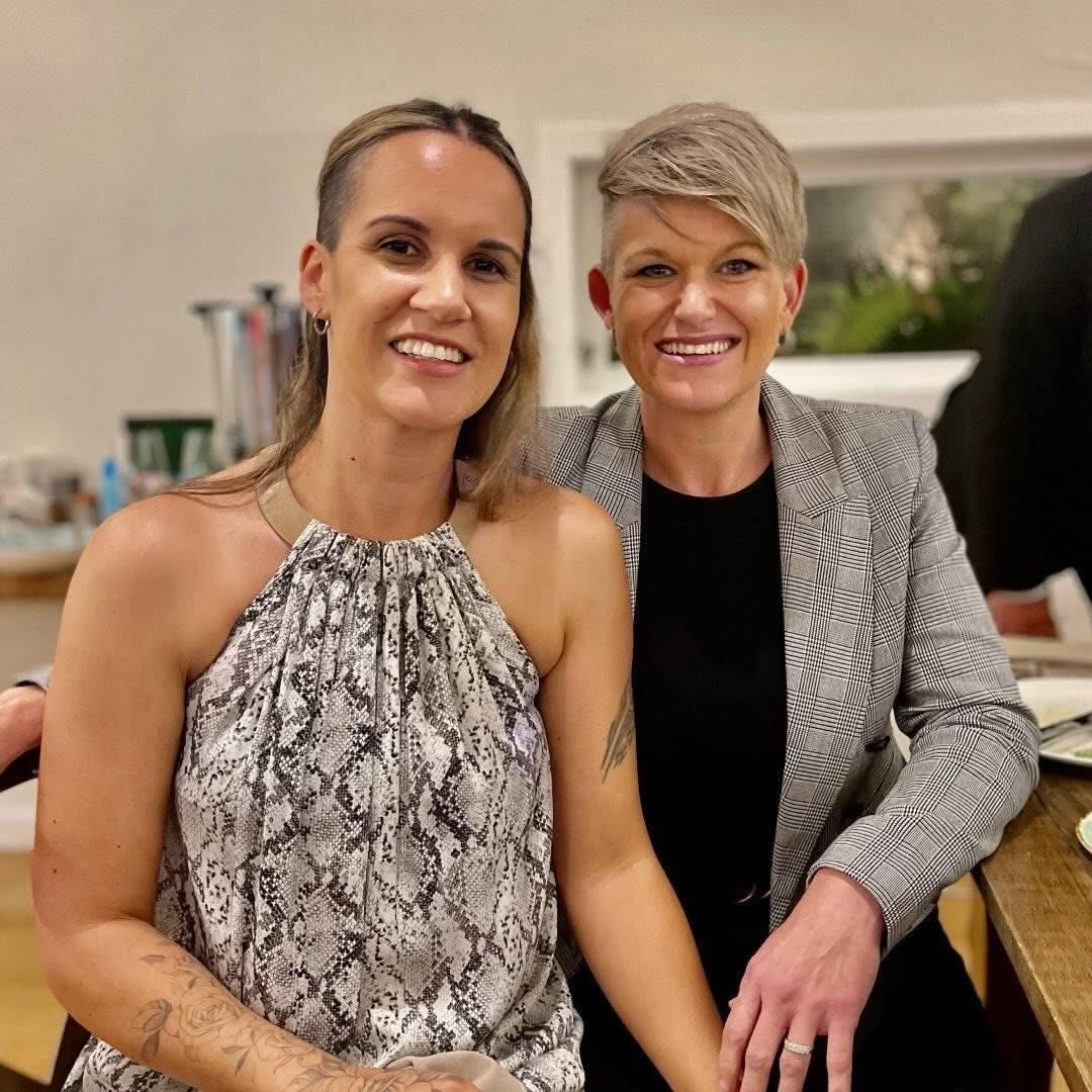The owners of Forage Store, Kelly & Jess sit together smiling at the camera, dressed up for an event.
