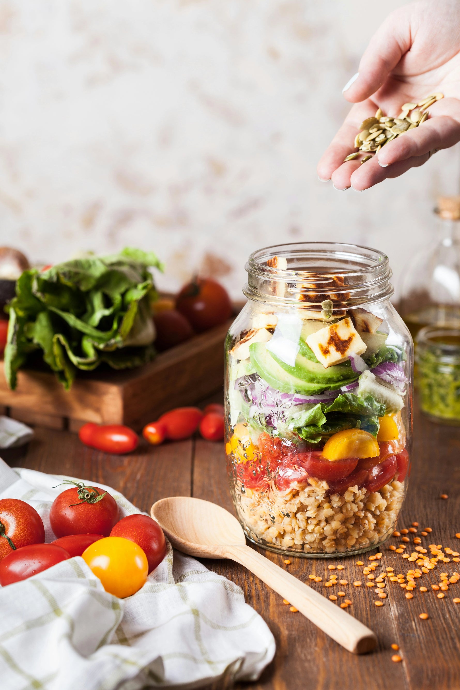 Mason jar salad with fresh ingredients on a wooden table